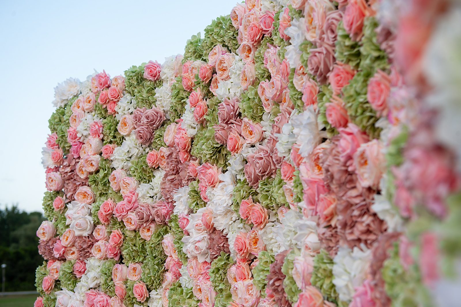 Close-up of green and white flower wall with eucalyptus and peach Real Touch roses